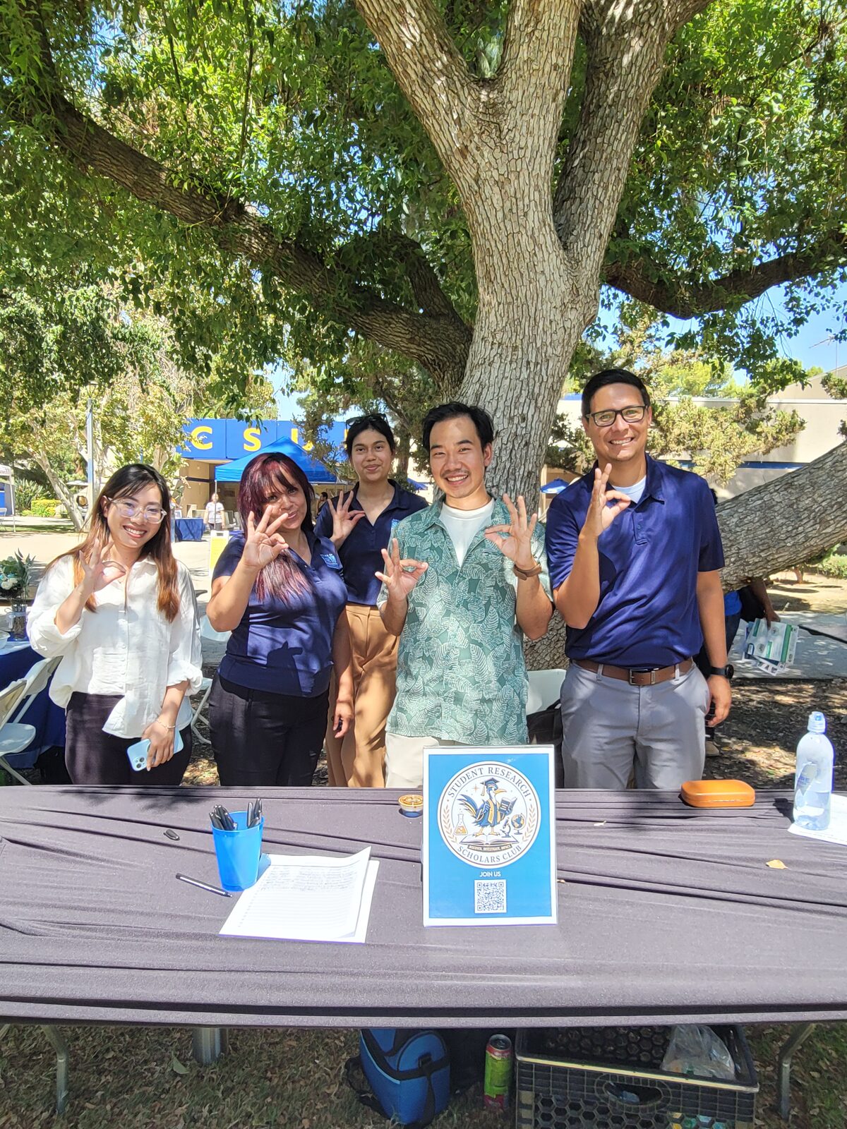 SRSC members standing behind the club table at the Fall 2026 CSUB club fair, with the club logo flyer and sign-up sheet on the table