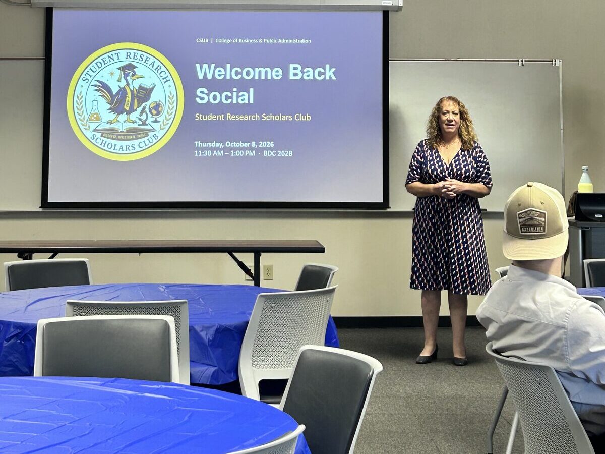 BPA Dean Dr. Deborah Cours giving opening remarks in front of the Welcome Back Social title slide